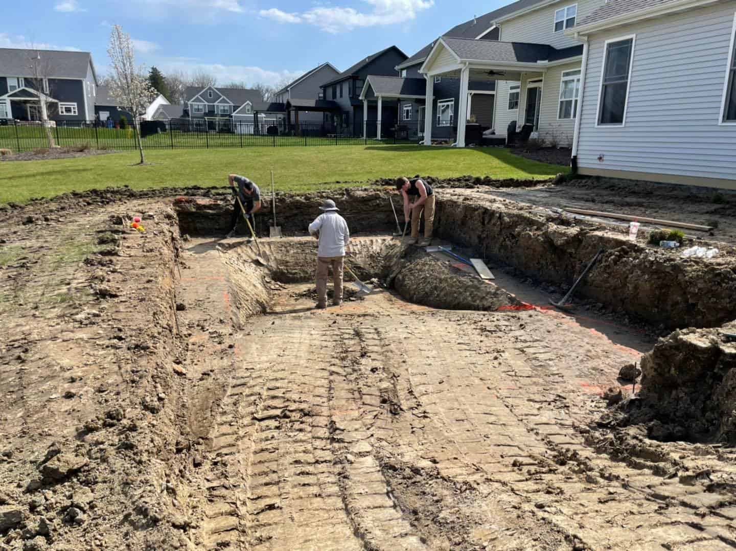 A group of people working on a pool in a backyard.