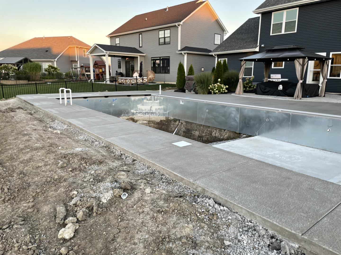 A swimming pool is being built in front of a house.
