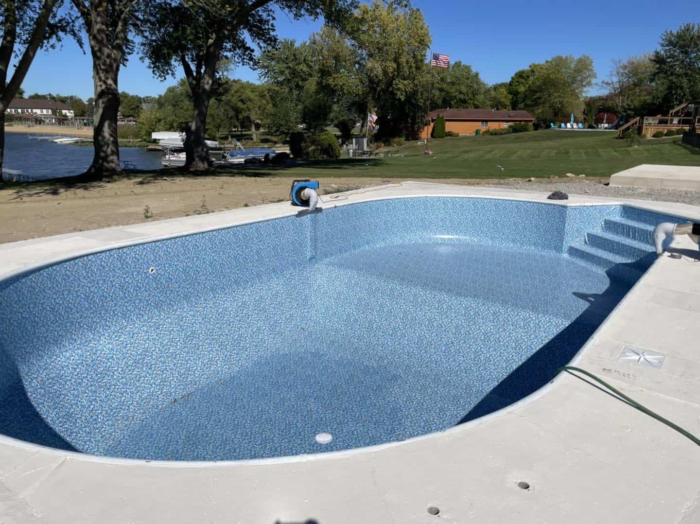 A swimming pool is being installed in a backyard.