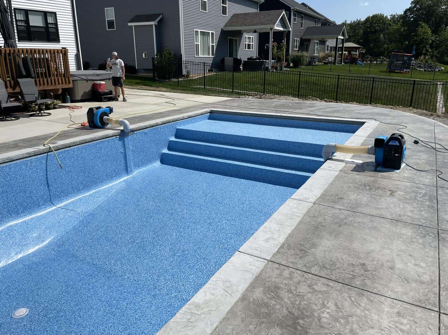 A pool is being cleaned with a pressure washer.