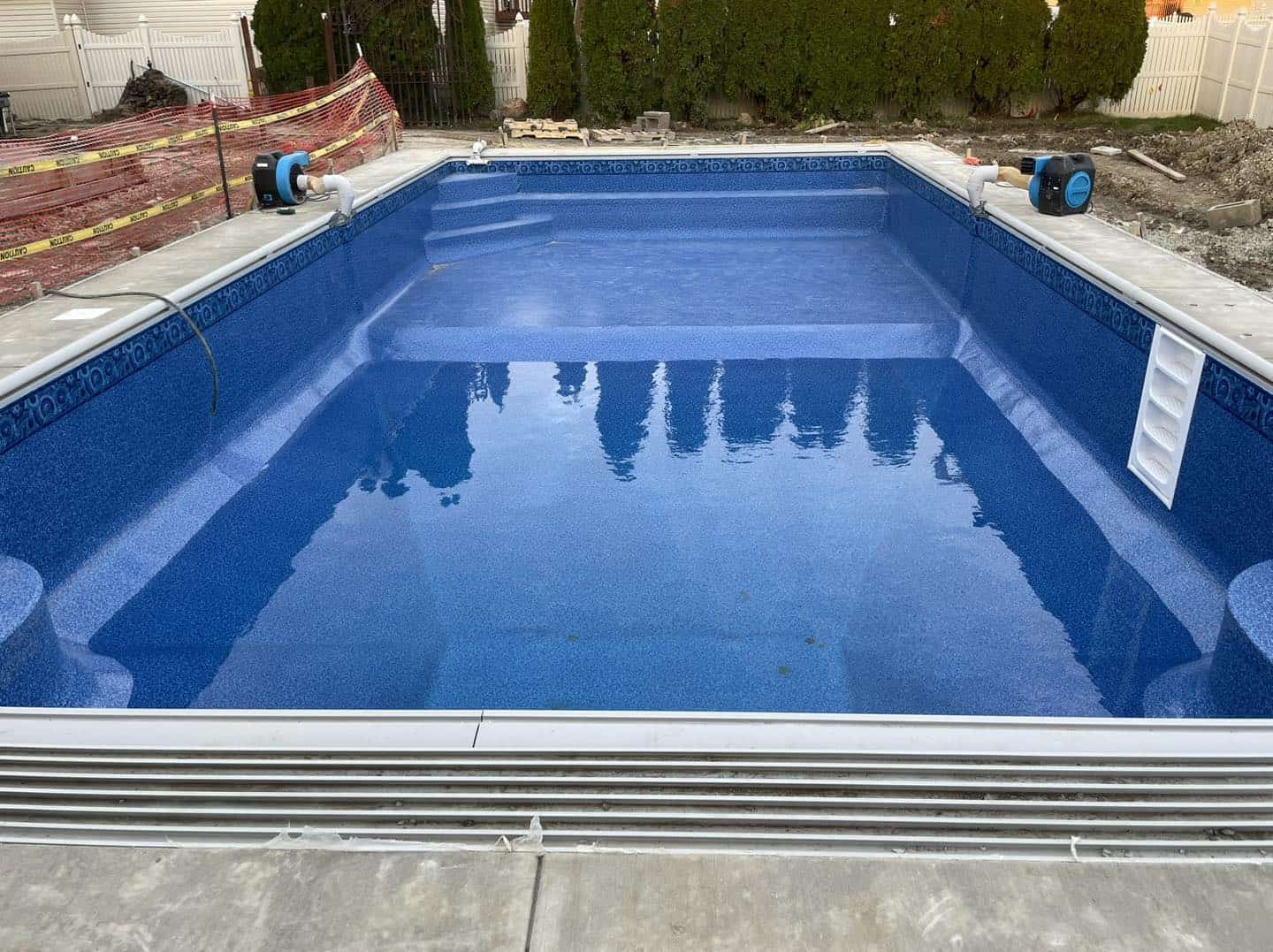 A swimming pool is being built in a backyard.